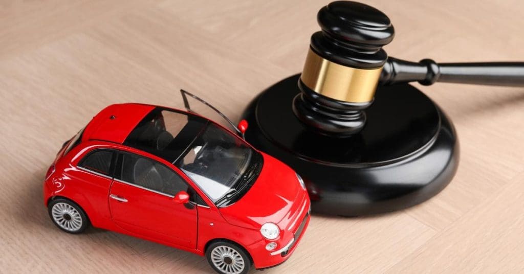 FCA BNPL regulation changes 2026: A red toy car parked next to a black and gold judge's gavel and sound block on a wooden surface.