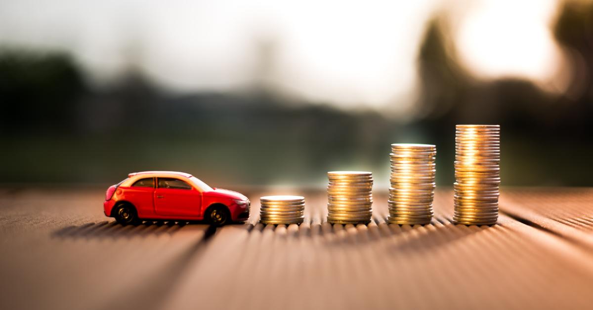 How a clear finance process improves customer experience A small toy car beside four ascending stacks of coins, symbolising growing savings or financing costs.
